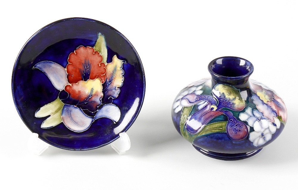 Two items of Moorcroft Orchid pattern pottery. Comprising: a vase, of squat bulbous form on dark