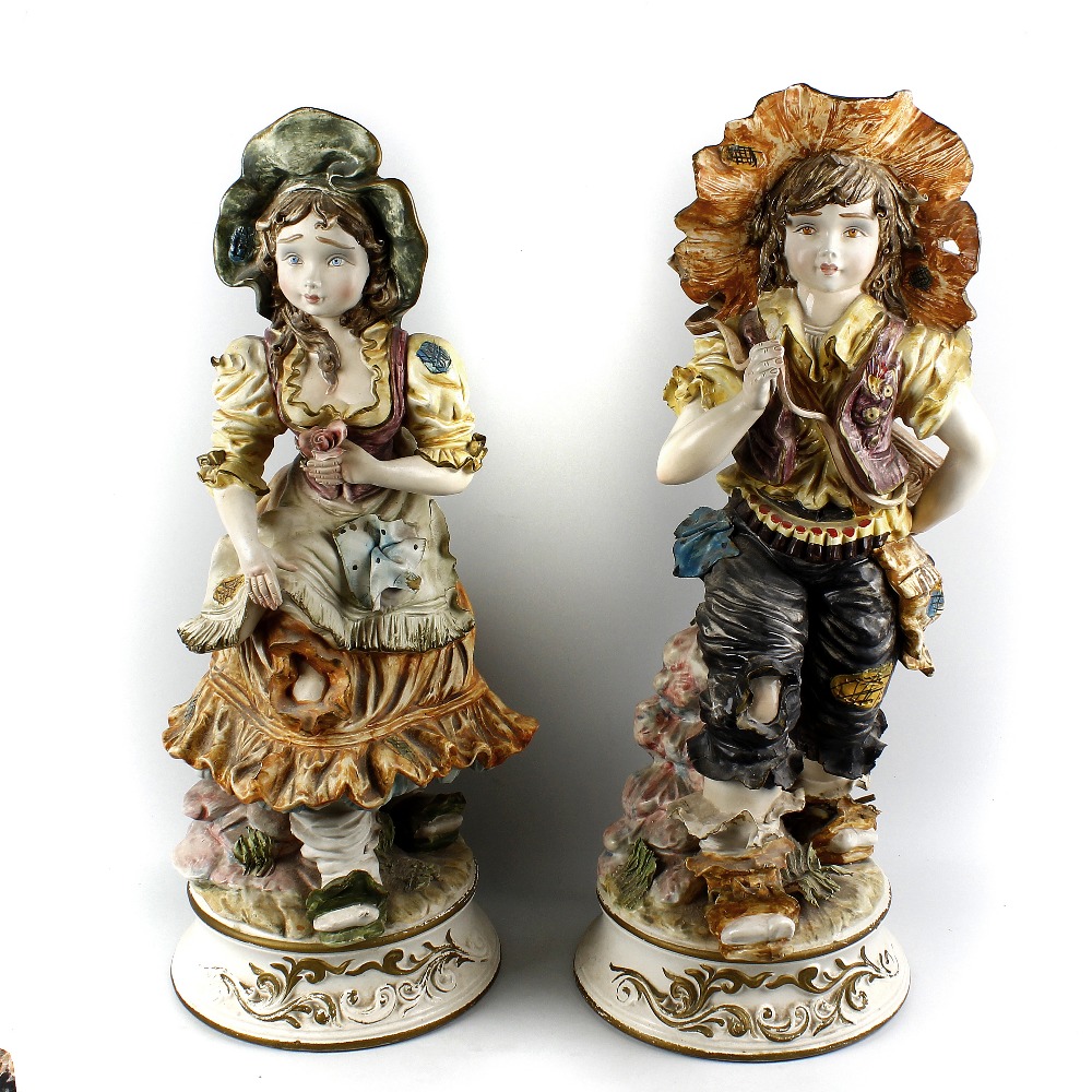 A large pair of Capodimonte figures Modelled as a boy and girl, he with rifle slung across his back,