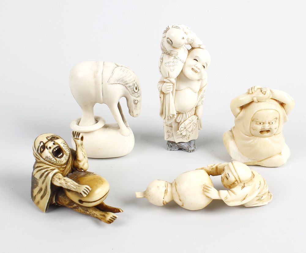 A group of five Japanese netsuke. To include a kneeling figure dragging a large gourd, a horse