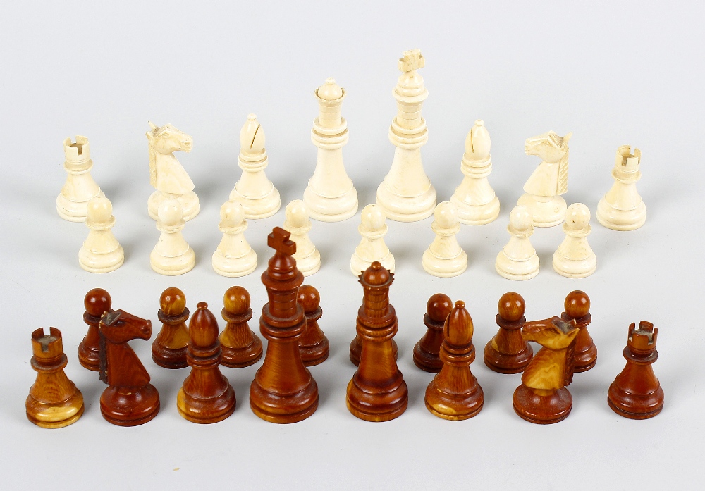 A stained ivory chess set. Comprising natural and brown stained sectional pieces, the kings of
