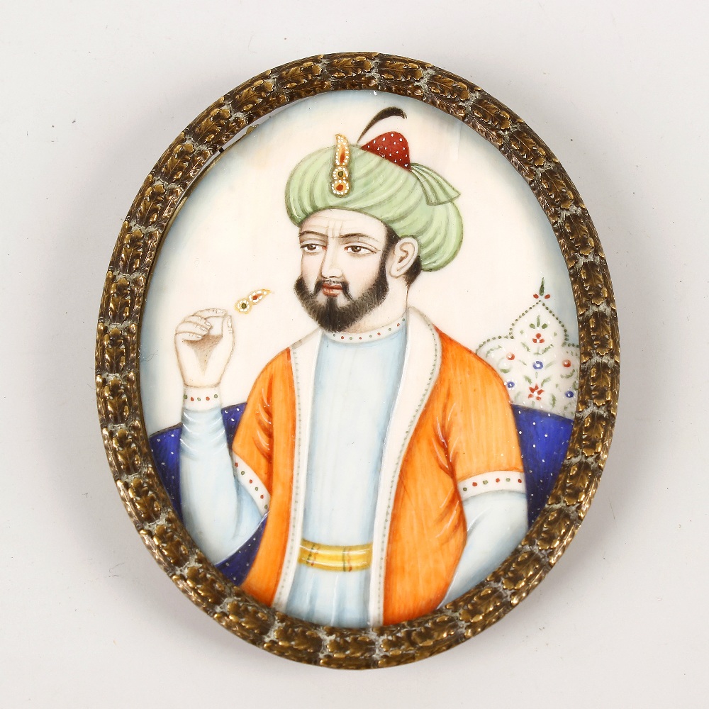 An Indian Mughal-type oval miniature on card. Depicting turbanned bearded male, waist-length, 3 x