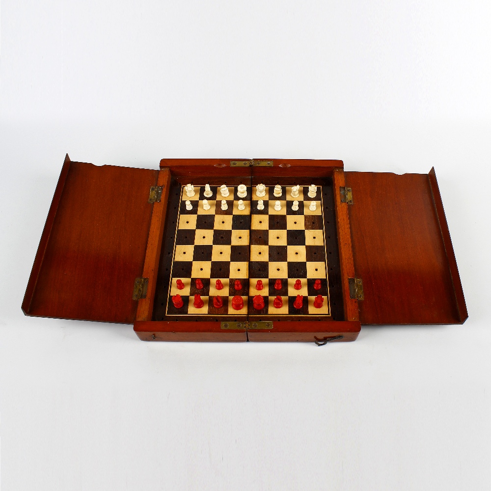 A mahogany-cased travel chess set. Early 20th century, the folding board with internal covers