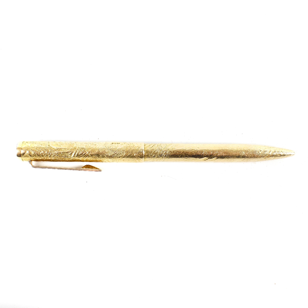 An Alfred Dunhill 9ct gold ballpoint pen, with molten textured body, twist mechanism, hallmarked
