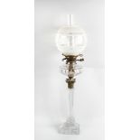 A glass paraffin lamp, with frosted spherical shaped shade over duplex burner, glass and brass