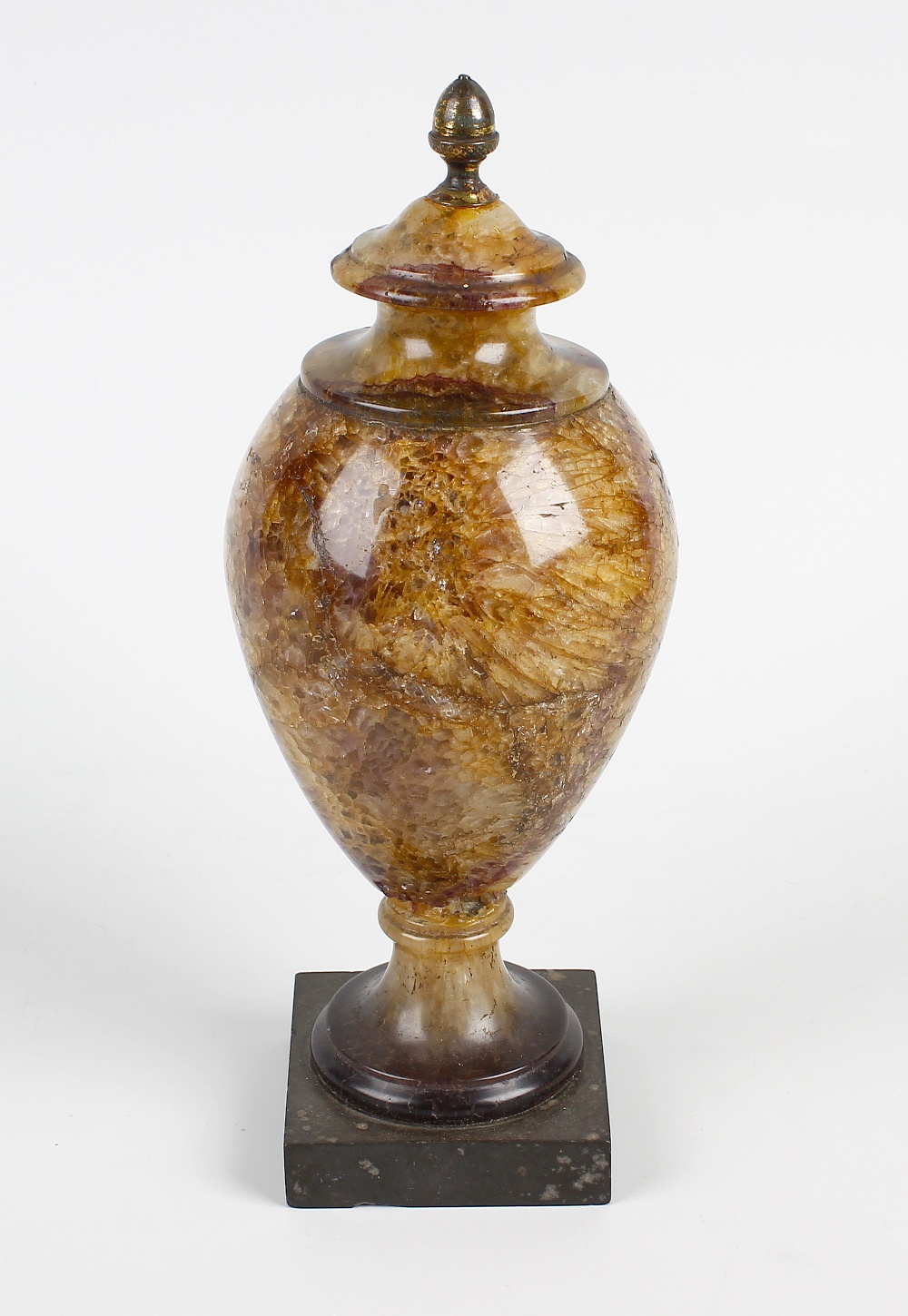 A Blue John 9th century urn. Of sectional form having brass acorn finial, the ovoid body of cream
