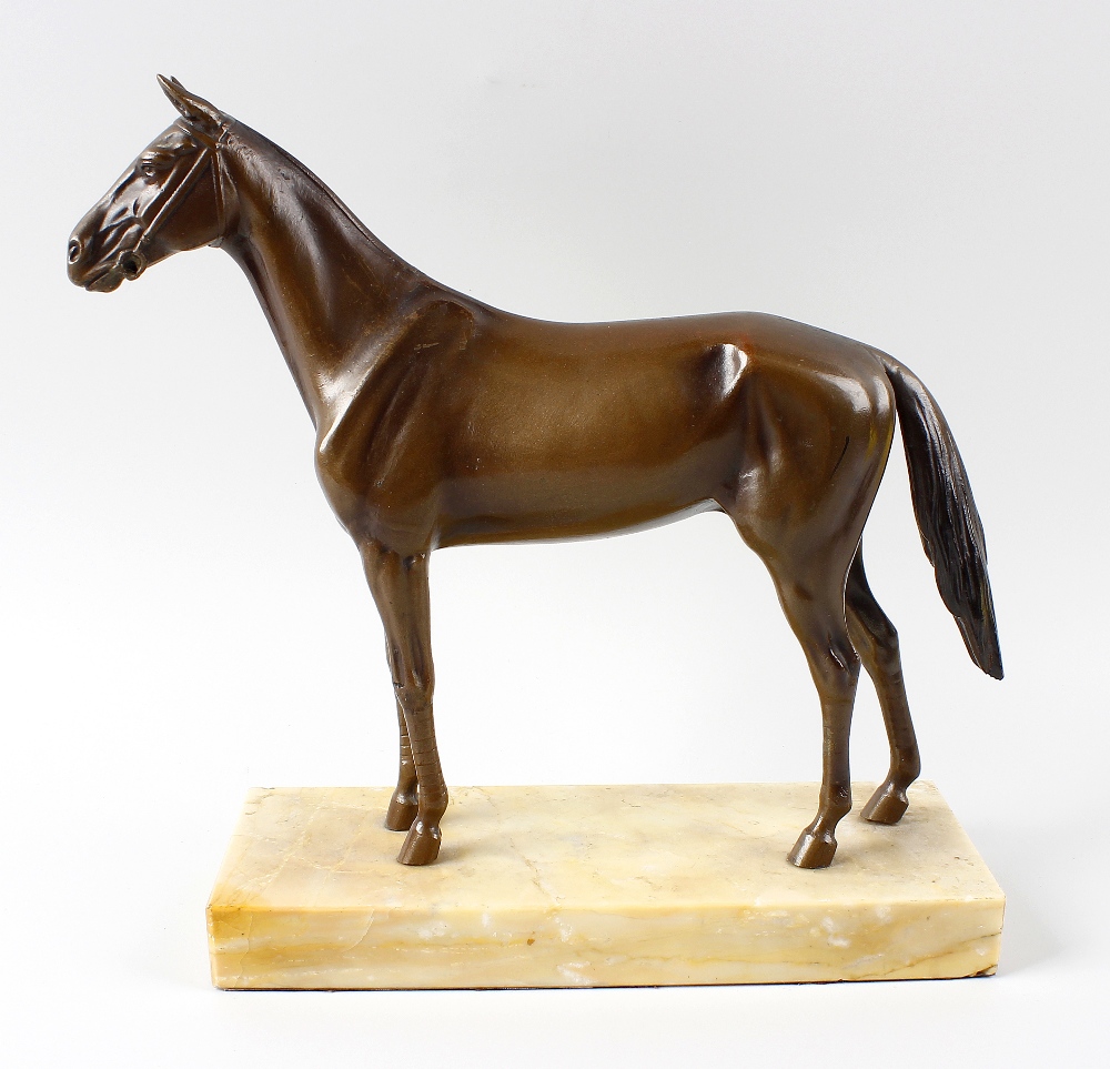 A bronze figure of a racehorse. Modelled wearing bridle and stood upon rectangular marble plinth,