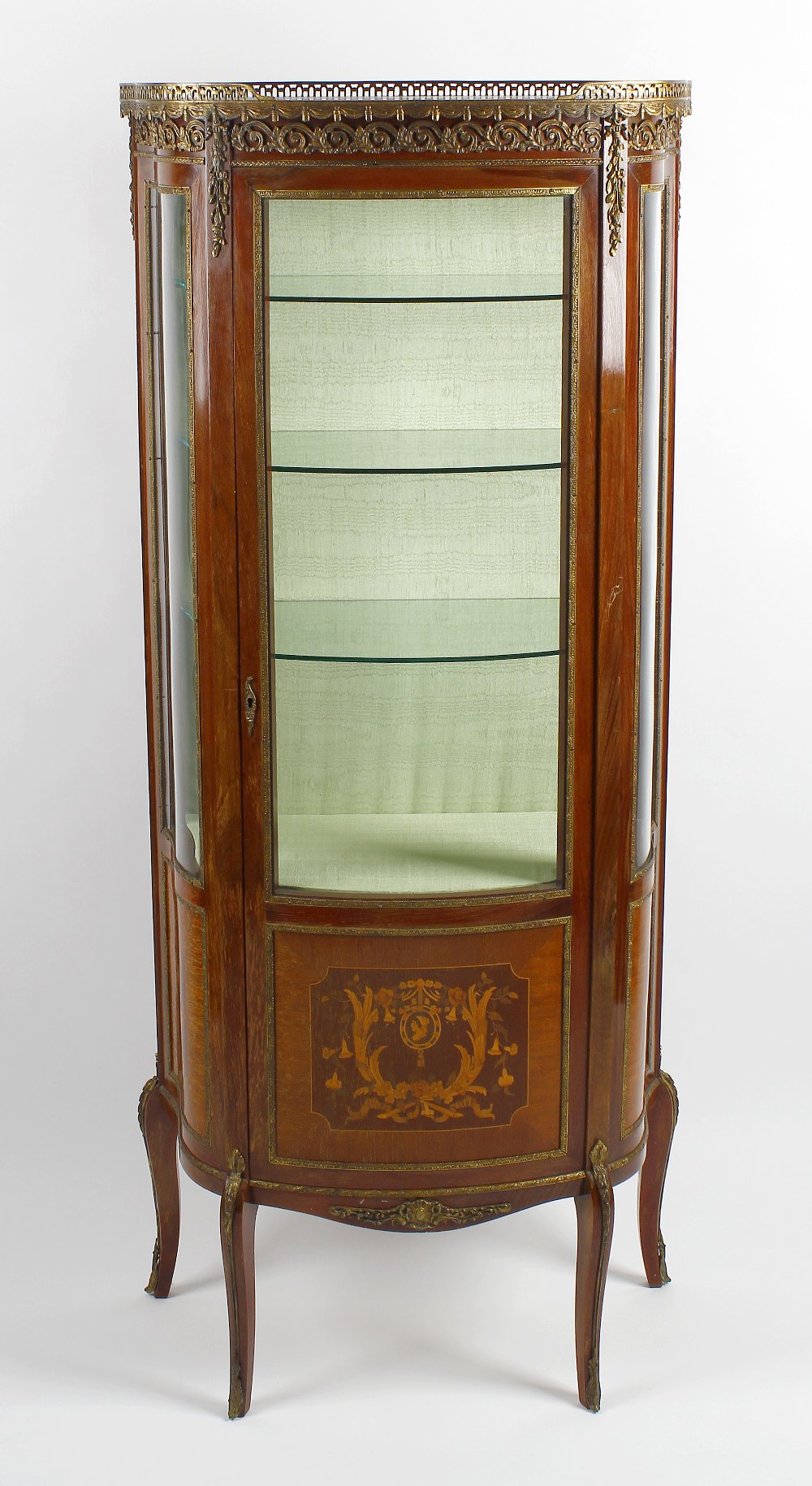 A 20th century French bow front vitrine or display cabinet Having a pierced gilt metal gallery