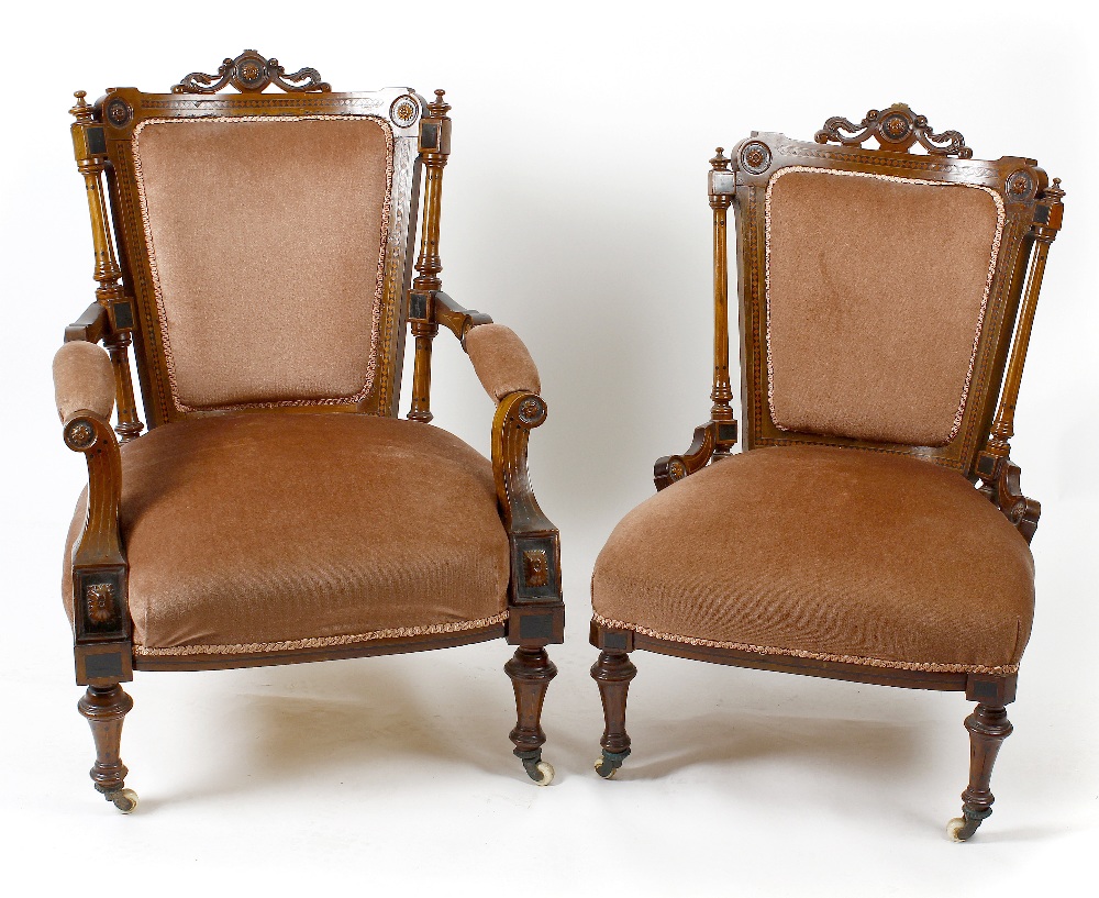 A late Victorian carved and inlaid walnut framed armchair, the pink upholstered back, above an