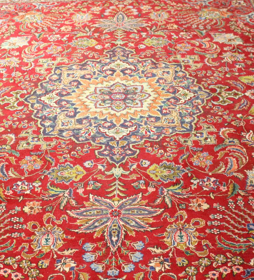 A large mid 20th century Persian carpet. The crimson field with lobed central medallion between