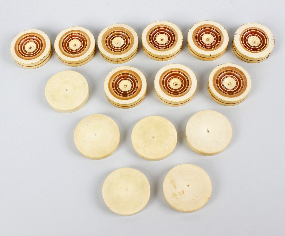 A set of turned and stained ivory counters. Each of circular outline comprising six plain examples