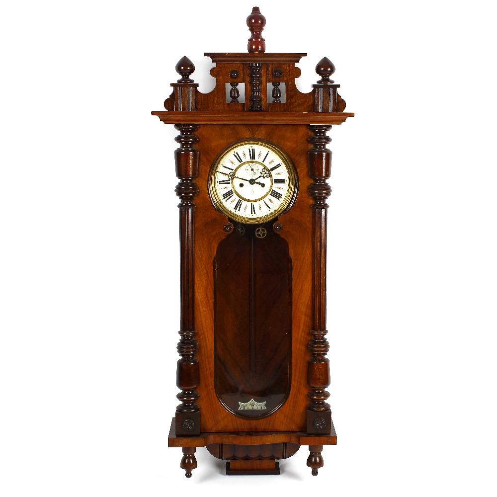 A Gustav Becker walnut and mahogany cased Vienna style wall clock. The shaped pediment above a