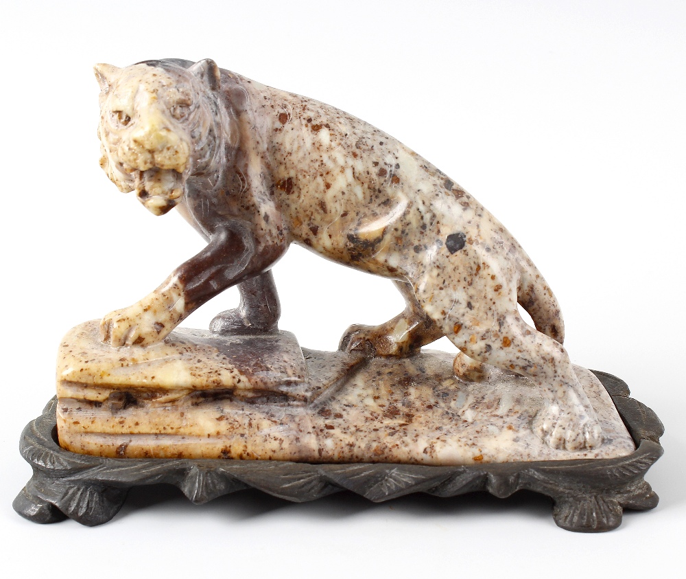 An Eastern hardstone figure of a tiger. Stood in crouched stance with open mouth upon a rocky base