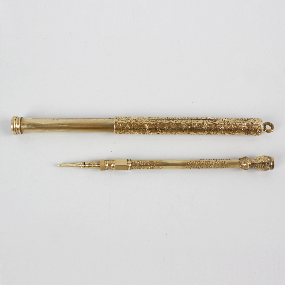 Two yellow metal retractable pencils. The first of cylindrical form having scrolling foliate