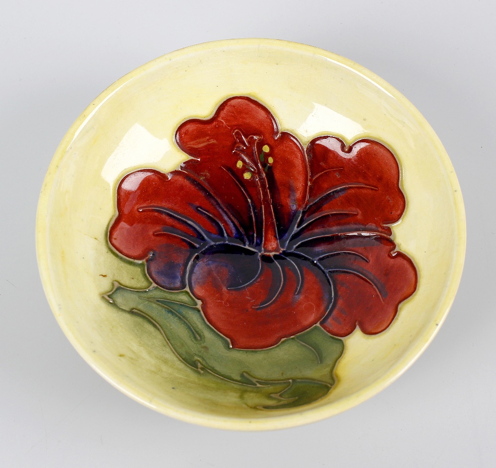 A small Walter Moorcroft dish. Of shallow form having central orchid flower upon a merging pale