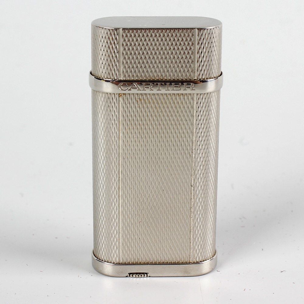 A Cartier silver-plated lighter with textured finish, 2.5 (6cm). Minor wear to body, including