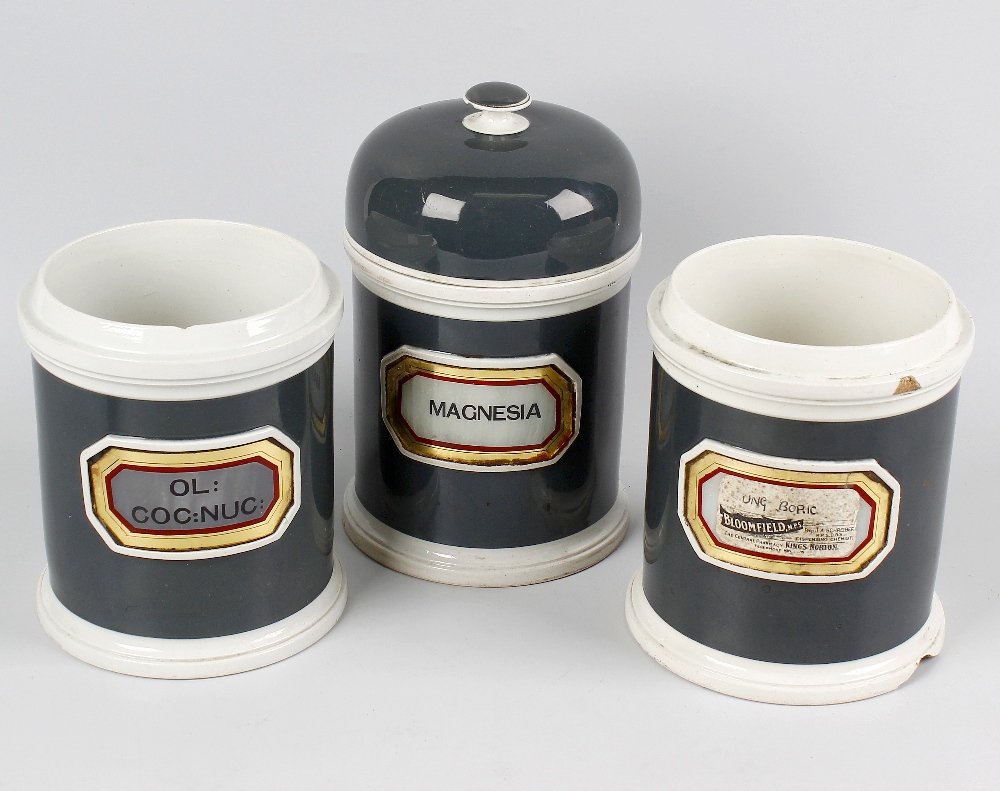 Seven late Victorian pottery apothecary jars, each of cylindrical form with dark green glazed