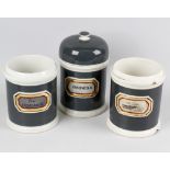 Seven late Victorian pottery apothecary jars, each of cylindrical form with dark green glazed