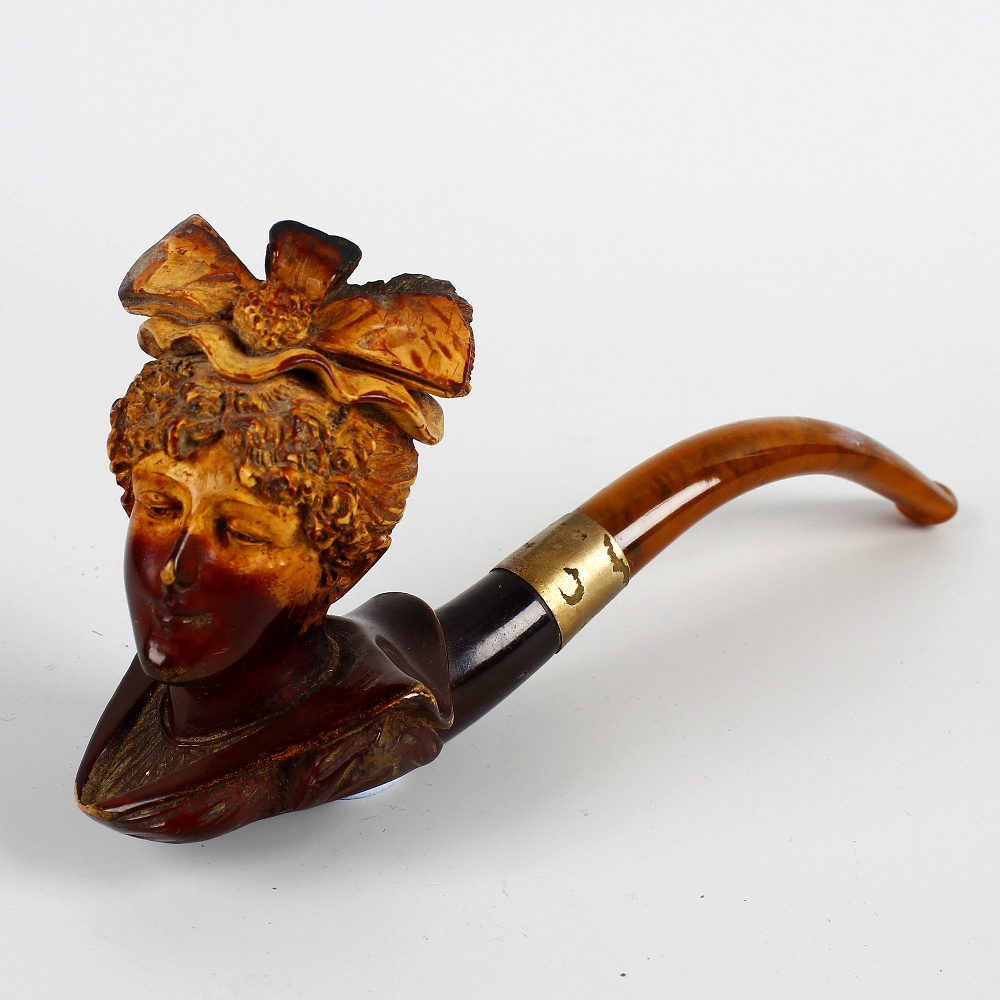 A 19th century carved meerschaum pipe. Modelled as a bust of a lady, with ribbon headdress and