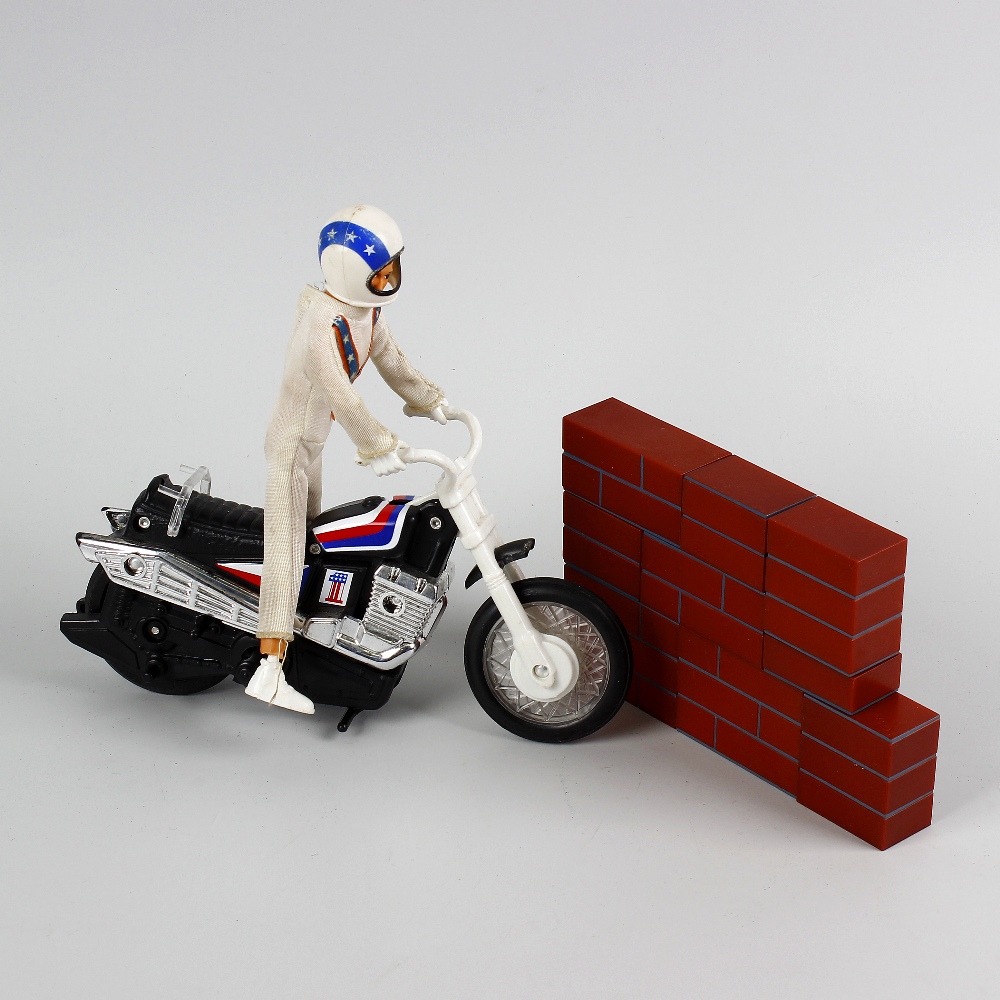 A box containing an Ideal Evel Knievel scramble van in original box, other Evel Knievel items, a