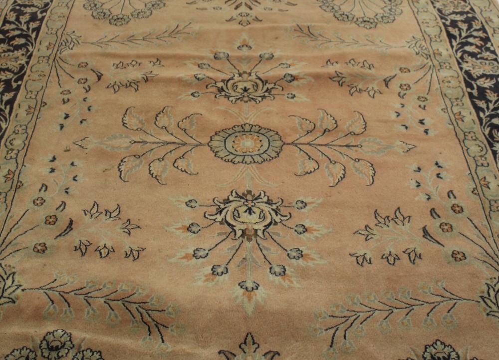 A carpet or rug. The central field sparsely decorated with floral motifs upon a pale pink ground, - Image 2 of 3