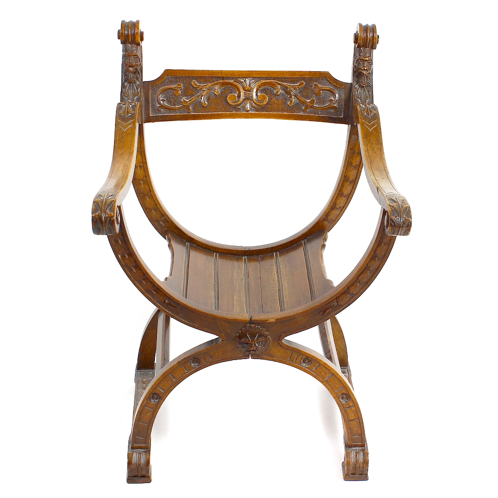 A late 19th century Continental carved walnut X-frame chair. The toprail decorated with foliate