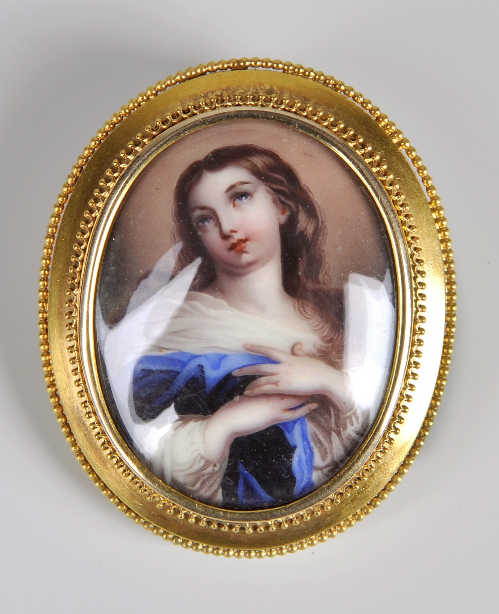 A 19th century oval portrait miniature brooch, female depicted half length with hands to chest and