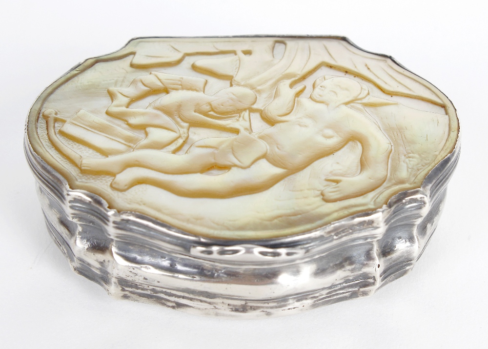 A mother-of-pearl mounted snuff box. Of organic form having low relief carved scene to the hinged