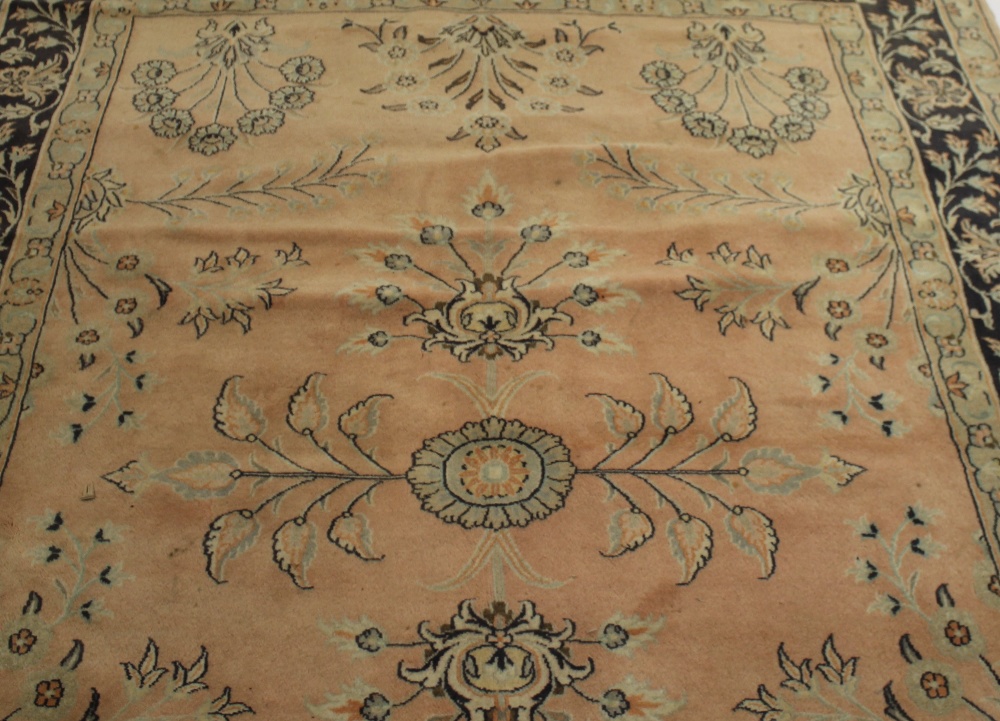 A carpet or rug. The central field sparsely decorated with floral motifs upon a pale pink ground, - Image 3 of 3