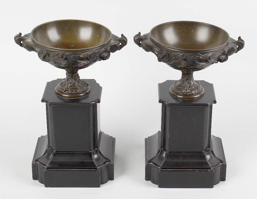 A pair of bronze pedestal urns. Each of shallow form with twin phoenix handles, the exterior