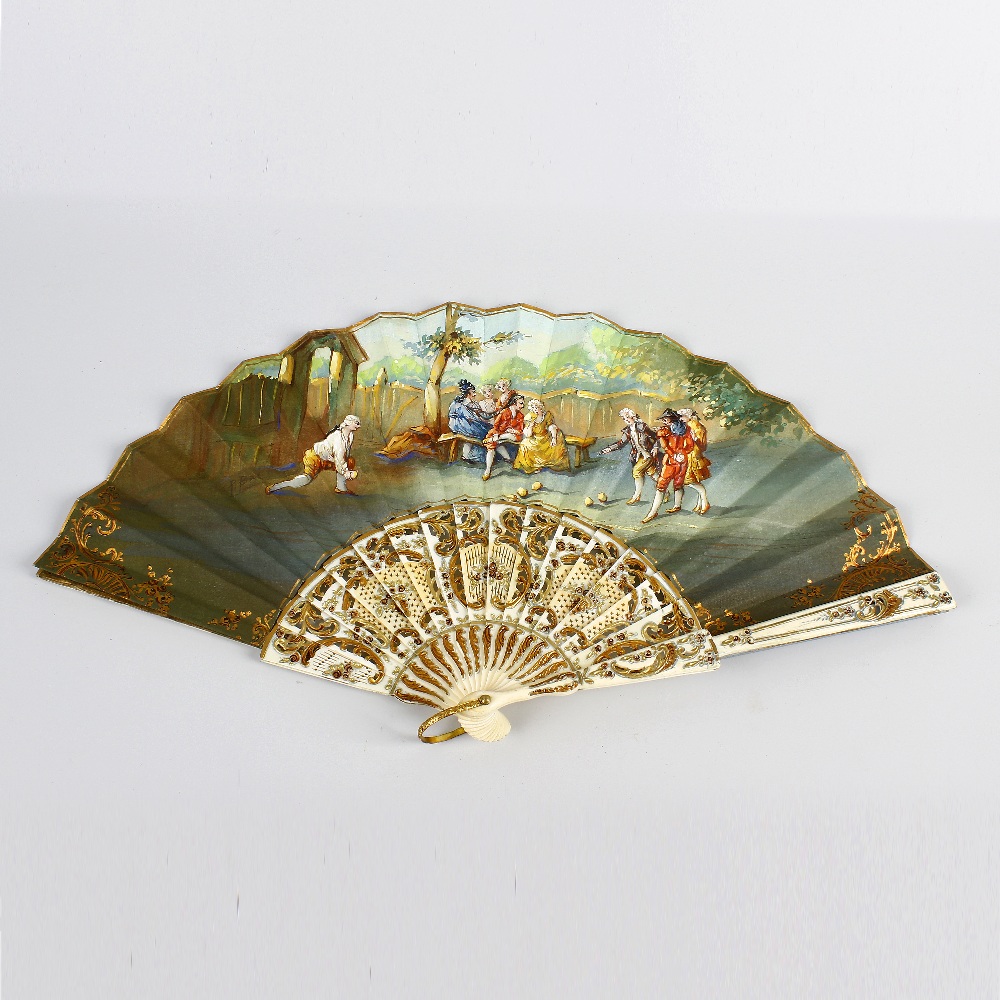 An early 20th century painted silk fan. Decorated with figures playing bowls before onlookers in a