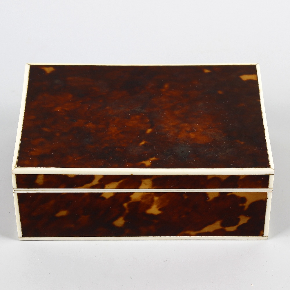 An early 20th century ivory-strung tortoiseshell cigarette box. Of rectangular form with hinged