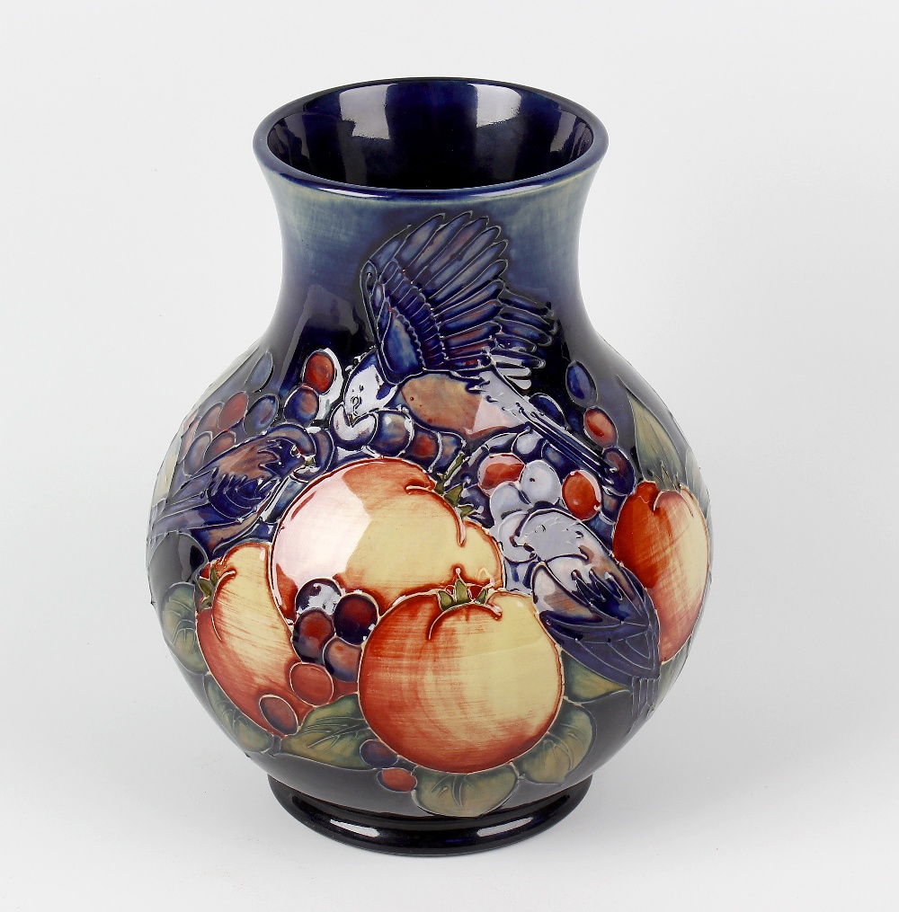 A Moorcroft pottery 'Finches' pattern vase. The bulbous body with tube-lined decoration on a blue