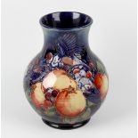 A Moorcroft pottery 'Finches' pattern vase. The bulbous body with tube-lined decoration on a blue