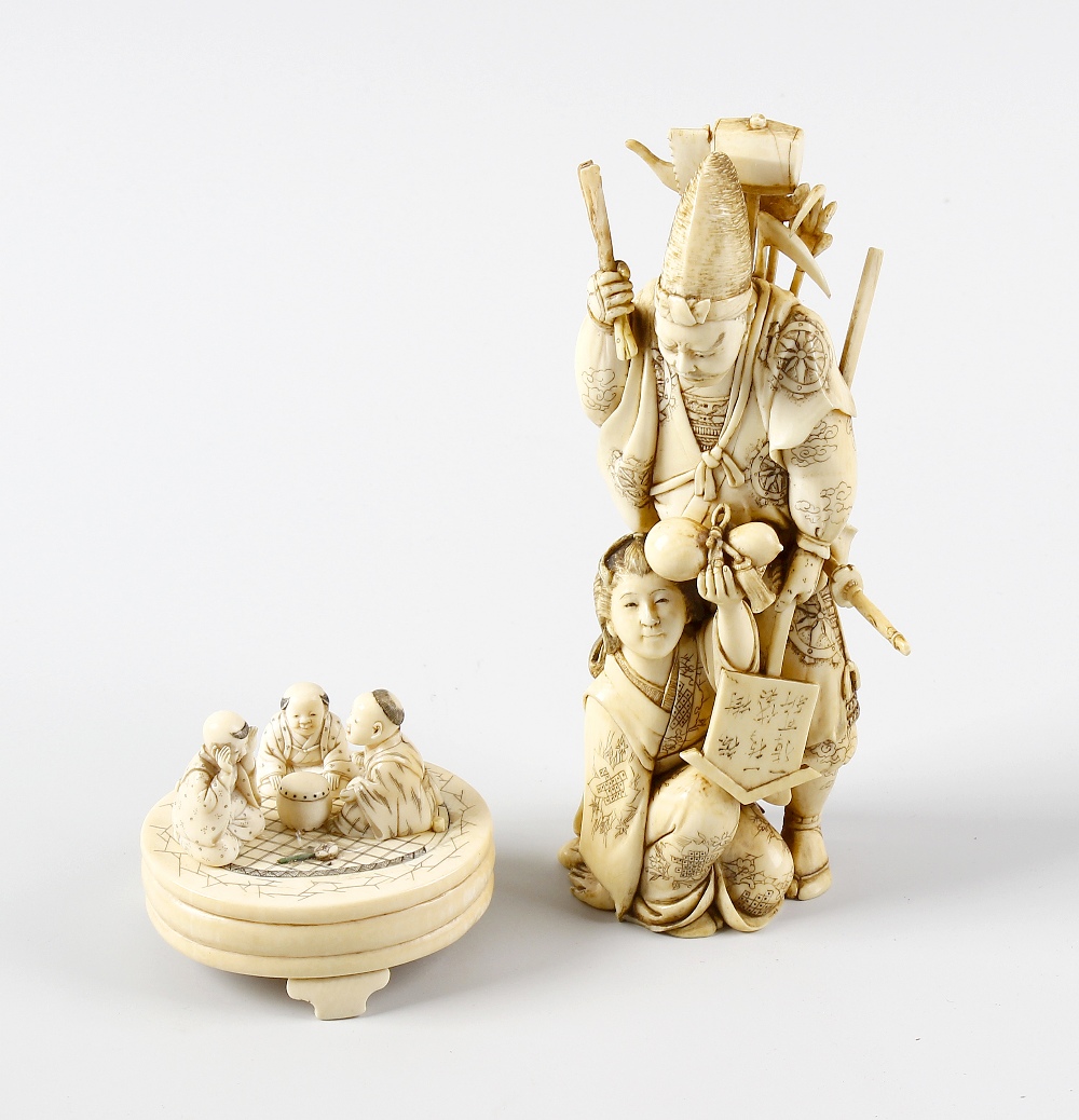 A 19th century carved ivory okimono, modelled as a male laden with sword and other tools, a female