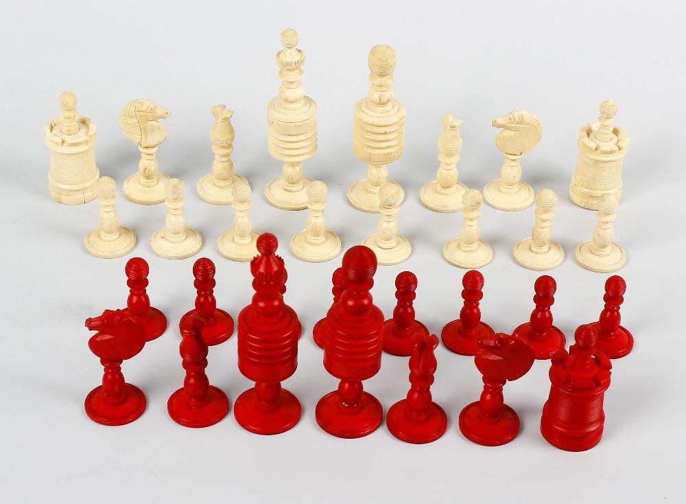 A Captain Cook stained ivory chess set. Comprising natural and red stained sectional pieces, the