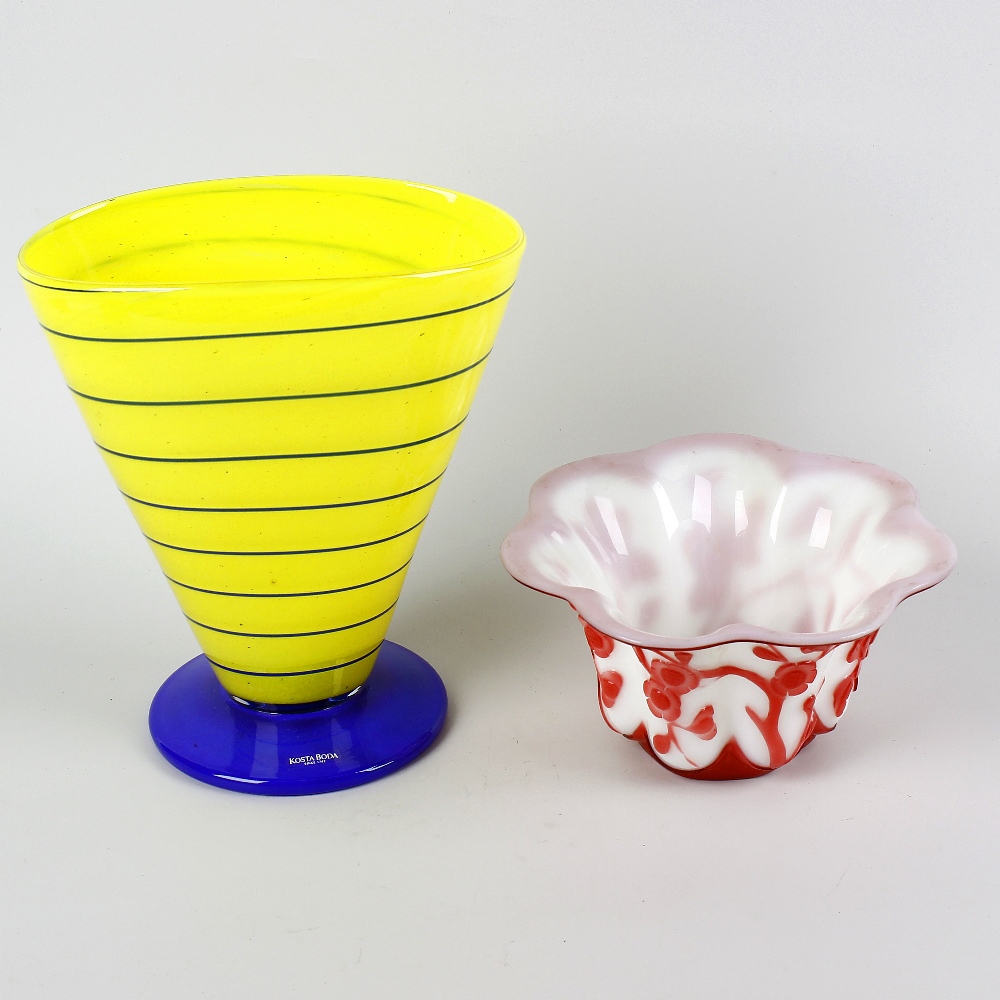 A box of assorted glass ware. To include a Kosta Boda yellow and blue glass trumpet vase, a