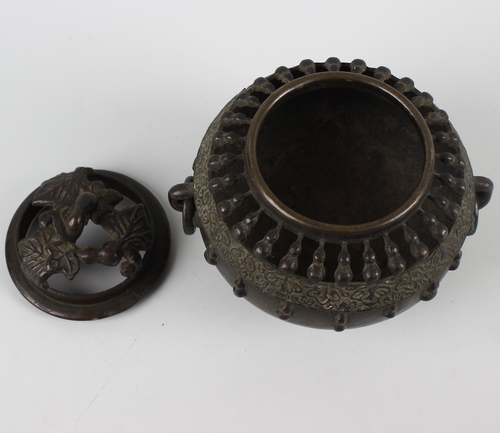 An Oriental bronze koro or incense burner and cover. Of spherical form with pierced domed foliate - Image 2 of 3