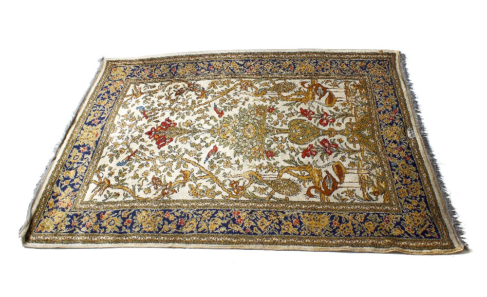 A Kirman-type 'Tree of Life' garden rug. The ivory filed decorated with birds flanking a tree,