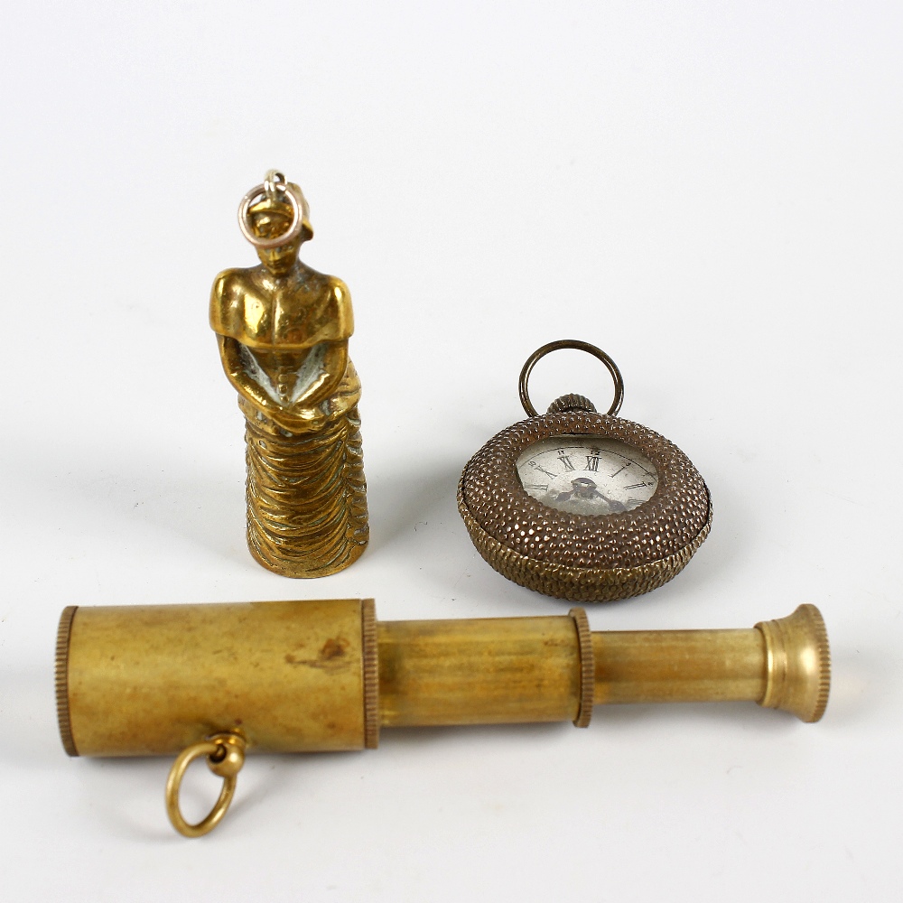 Three objects of virtue. Comprising: a brass novelty cigar-cutter in the form of a 'crinoline lady',