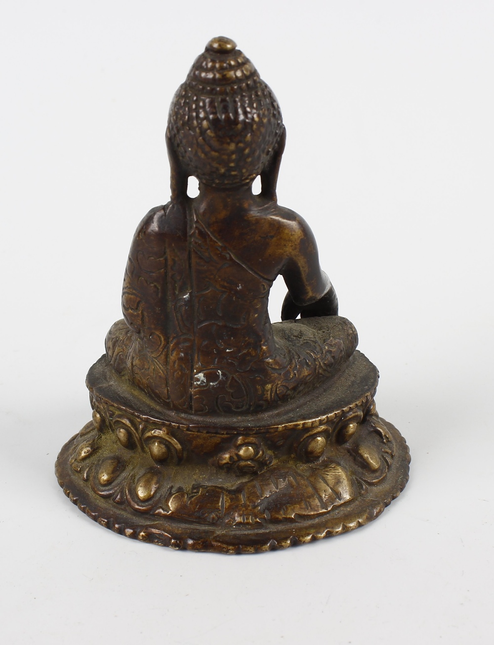 A South East Asian cast bronze figure of a Buddha. Modelled in seated Lotus position holding a - Image 3 of 3