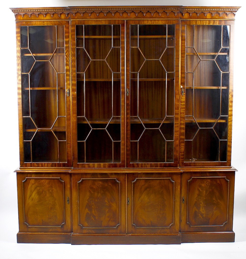 A mahogany reproduction breakfront bookcase cabinet The upper section with dentil cornice and