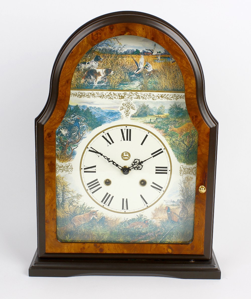 A reproduction walnut mantel clock. Decorated with various hunting scenes to the arch and spandrels,