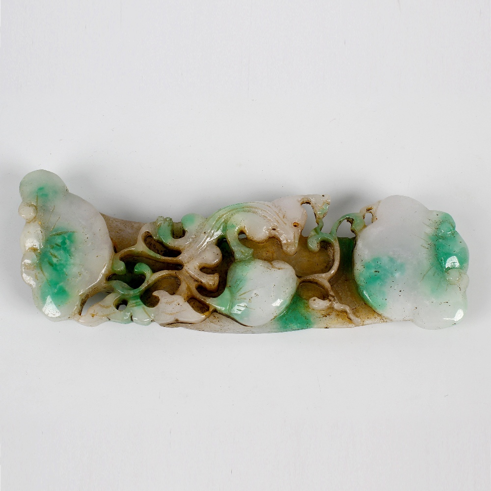 A carved jade handle or scroll-weight Modelled with assorted fruit amidst scrollwork, of pale
