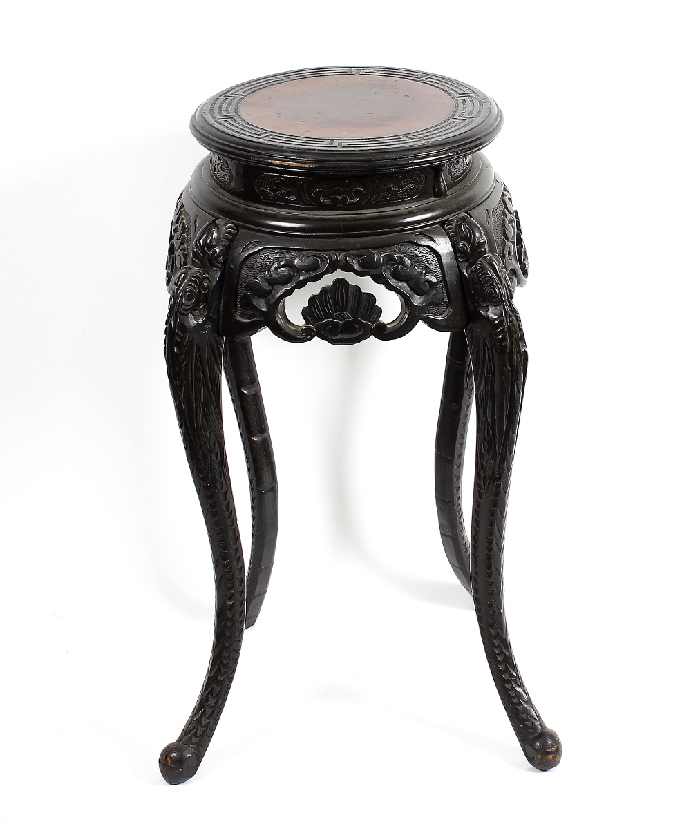 A Chinese carved stained pine vase stand The circular top with greek key border on scroll-carved