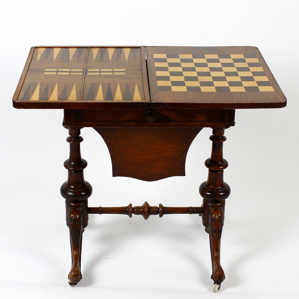 A mid Victorian inlaid walnut fold over games/work table. the figured quarter veneered top with