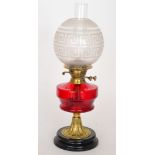 A Victorian brass oil lamp with ruby red