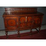 A 1920s Jacobean style carved oak sidebo