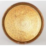 A large circular brass tray decorated wi