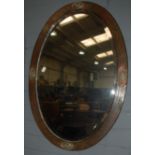 An Art Deco copper framed oval bevelled