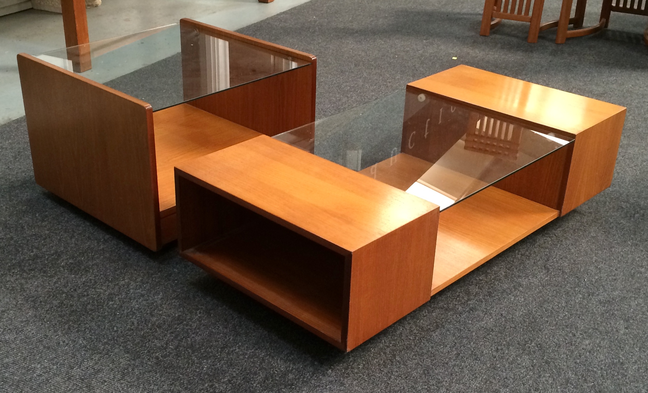 Tapley Furniture - Two teak and plate glass low level units on castors, height 41cm x width 55cm,